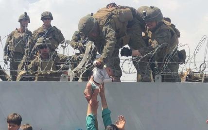 Мережу облетіли кадри з Кабула, на яких військовому США через колючий дріт передають немовля