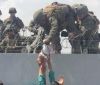 Мережу облетіли кадри з Кабула, на яких військовому США через колючий дріт передають немовля