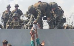 Мережу облетіли кадри з Кабула, на яких військовому США через колючий дріт передають немовля