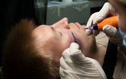 Житель Києва зробив на обличчі татуювання з логотипом магазину в обмін на iPhone 12